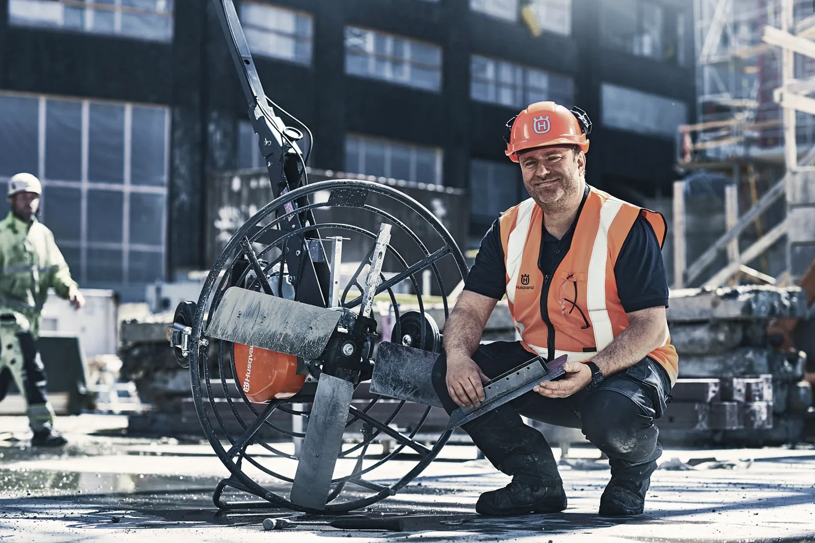 Service technician kneeling beside a wire saw on a construction site